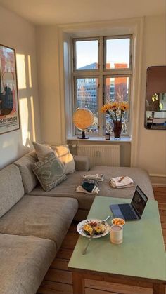 a living room filled with furniture and a laptop computer on top of a coffee table