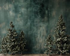 three small trees sitting on top of a wooden table in front of a green wall