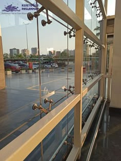 an empty parking lot next to a building with lots of glass on the windows and doors