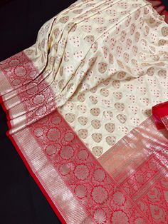 Gorgeous Ivory Cream / Light Gold Silk Saree with Grand Pallu. Floral BUttas designs all over the body of the Saree with red  borders and Hot pink Pallu.  A complete designer wear Saree.  Border  is 8 1/2 inches wide.  Item : Saree Base Fabric : Banarasi Silk Color : Ivory Cream with Red  Blouse piece : Comes with un-stitched Blouse piece. Blouse material : Banarasi Silk Work : Woven, Zari Weaved Fall & Edging (Yes/No) : Yes Disclaimer -: - Color variation is possible due to various reasons like phone or desktop setting, resolution etc. Please don't hold us responsible. Our aim is to put the exact color of the Saree. - Colors are very Subjective. Hence a color understood by us can be different then yours.  - If the Saree is Pure Silk, we will put it very clearly in our listing that it is P Red Banarasi Silk Saree, Gold Silk Saree, Banarasi Silk Saree, Saree Border, Red Saree, Red Blouse, Readymade Blouse, Wear Saree, Gold Silk