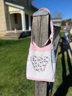 a handbag hanging on a fence post in front of a house