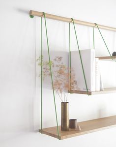 a shelf with some books on it in a room that has white walls and wooden shelves