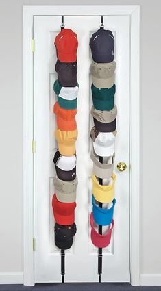 several hats hanging on hooks in front of a door