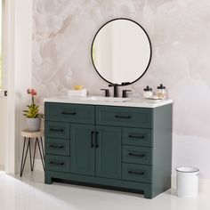 a bathroom vanity with a round mirror above it