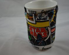 a star wars themed coffee cup on a white tablecloth with the words city comics printed on it