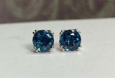 "Natural Round London Blue Topaz set in a Sterling Silver Filigree Double prong setting. These earrings come with a pair of sterling silver earring backings. Watch as the medium-to-deep grayish-blue sparkles with hints of green tinge. This uncommon Topaz is highly sought after for the excellent even blue color saturation. HOW WE DO BUSINESS 📦 Professionally Packed 😎 Hassle-free 30 Day Return Policy. 💍 High-Quality Products 🥳 Item Will Ship in Gift Bag or Box 🌎 Ethically Sourced Material Mai London Blue Topaz Earrings, Blue Furniture, Blue Topaz Earrings, Blue Sparkles, Glass Cabinet, Tiny Stud Earrings, Sterling Silver Filigree, Topaz Earrings, London Blue Topaz