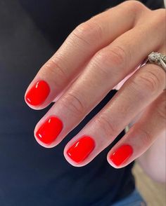 a woman's hand with red nail polish on it and a ring in the middle