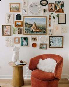 an orange chair sitting in front of a wall filled with pictures and other things on it