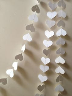 some paper hearts hanging from the side of a wall