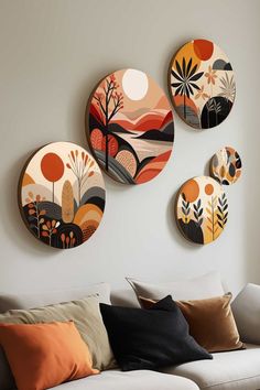 three decorative plates mounted on the wall above a couch in a living room with white walls