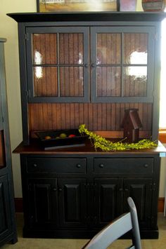 a black china cabinet with glass doors and drawers