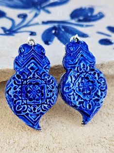 pair of blue earrings sitting on top of a table