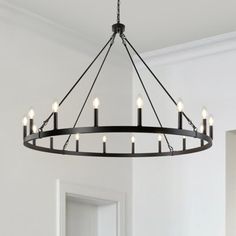 a chandelier hanging from the ceiling in a room with white walls and flooring