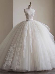 a white wedding dress on display in front of a mannequin's head