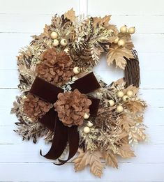 a wreath with pine cones and berries on it