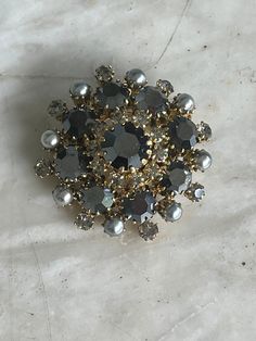 Vintage stone set brooch by Pricheré. Made in Neu Gablonz, Bavaria, South Germany in the early 1960s. The round brooch is set with anthracite coloured stones and faux pearls. It's signed 'Pch' on the back. Pricheré belonged to the much more famous  jewellery design company, Max Müller. Condition is perfect, unused. The brooch is 4.3 cm in diameter. Vintage Brooches With Sparkling Stones As Gift, Vintage Brooches With Sparkling Stones For Gift, Victorian Jeweled Brooches For Party, Antique Rhinestone Brooches For Party, Formal Silver Jeweled Brooches, Silver Jeweled Brooches For Formal Occasions, Formal Round Costume Jewelry Brooches, Jeweled Evening Costume Jewelry Brooches, Silver Jeweled Brooches For Evening