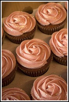 cupcakes with pink frosting in a box