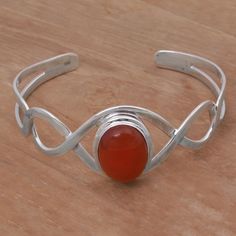 A helix of sterling silver flanks a stone of orange-red carnelian featuring a minimalist and elegant design reminiscent of DNA strands. This cuff bracelet is crafted by Balinese artisan Komang Suastra who has been involved in jewelry from a young age. Simple Cuff Bracelet, Carnelian Bracelet, Silver Signet Ring, Silver Gemstone Jewelry, Silver Chain Bracelet, Minimalist Bracelet, Sterling Silver Cuff Bracelet, Sterling Silver Bangles, Sterling Silver Cuff