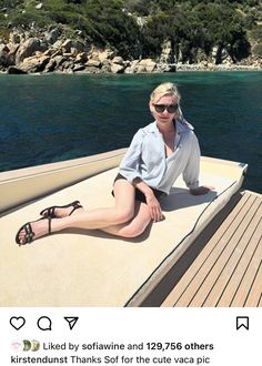 a woman is sitting on the back of a boat in the water with her legs crossed