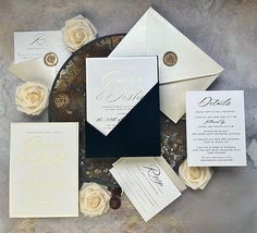 the wedding stationery is laid out on a black and white plate with rose petals