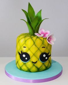 a pineapple shaped cake with flowers on it's top and eyes drawn on the side