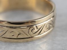 This handsome vintage band is easy and comfortable to wear! Beautifully stylized scrolling designs waft their way across the top of the band and are complemented by the smooth polish of the background. Metal: 14K Yellow Gold Width of Band: 5.8 mm Height off Finger: 1.3 mm Ring Size: 8.50 Marks: "12 14LK" Stamped on the inside band Engraved Yellow Gold Bands For Formal Occasions, Formal Gold Engraved Bands, Formal Engraved Gold Bands, Classic Gold Engraved Bands, Classic Engraved Gold Bands, Gold Classic Adjustable Band, Classic Adjustable Gold Bands, Classic Adjustable Gold Band, Gold Thick Decorative Band