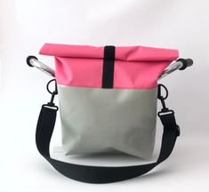 a pink and grey bag sitting on top of a white table