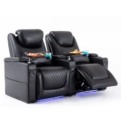 two black leather reclining chairs sitting next to each other on top of a white surface