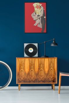 an old record player sits on top of a cabinet in front of a blue wall