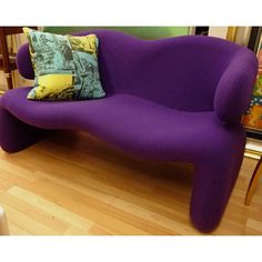 a purple couch sitting on top of a hard wood floor