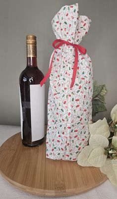 a bottle of wine sitting next to a bag on top of a wooden tray with a corkscrew