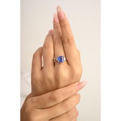 a woman's hand holding an engagement ring with a blue sapphire stone on it