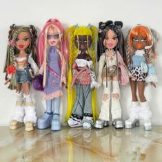 five dolls are lined up against a wall