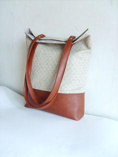 a brown and white bag sitting on top of a white table next to a wall