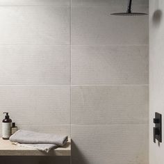 a bathroom with a sink, shower head and soap dispenser on the counter