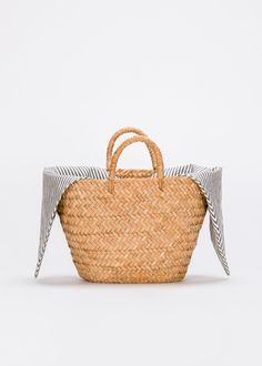 Our Sur straw tote is a modern staple that will work with anything in your wardrobe. Customize it with a liner or playful pom poms for a tote that's uniquely yours. Handbag accessories sold separately here. Handcrafted from all-natural woven straw using a time-honored Filipino basketweaving technique. Measures 17.5" W by 9.5" H by 5.5"D with a 4.5" handle drop. *Bag sold without liner. Natural Cotton Straw Bag For Travel, Spring Natural Cotton Straw Bag, Natural Cotton Straw Travel Bag, Spring Natural Straw Cotton Bag, Rectangular Cotton Straw Bag For Summer, Casual Spring Cotton Straw Bag, Basket Style, Velvet Clutch, Straw Clutch