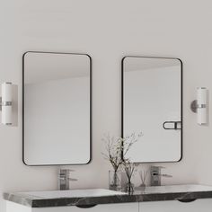 there are two mirrors on the wall above the sinks and one is holding a vase with flowers