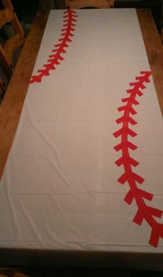 a baseball themed table runner with red stitches