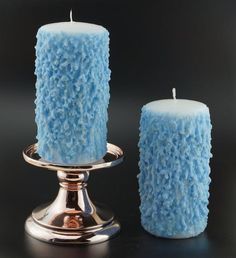 two blue candles sitting next to each other on a table