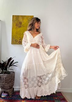 Handmade Bohemian Lace Trim Wedding Dress - Vintage-Inspired with Batwing Ruffle Sleeves and Adjustable Back Tie This flowing bohemian lace trim wedding dress is perfect for free-spirited brides or special occasions. Handmade with 100% soft cotton and delicate lace, it features romantic batwing ruffle sleeves and a flattering elastic waist. The dress is fully lined for comfort and comes with adjustable strings at the back to ensure a custom fit. The off-white beige fabric, paired with white lace Tiered Gown, Vintage Inspired Dresses, Beige Fabric, Boho Maxi, Free Spirited, Ruffle Sleeves, Boho Maxi Dress, Wedding Dresses Vintage, Dress Vintage