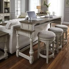 a living room filled with furniture and a laptop computer on top of a table in front of a couch