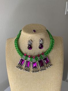 A gorgeous jewelry set consisting of an purple stone necklace on green thread, with matching earrings and a nose piece. Traditional Adjustable Purple Jewelry, Traditional Purple Jewelry For Festival, Purple Traditional Festival Jewelry, Bohemian Green Necklaces With Matching Earrings, Bohemian Green Necklace With Matching Earrings, Adjustable Green Amethyst Jewelry, Bohemian Purple Jewelry For Festive Occasions, Bohemian Green Amethyst Jewelry, Bohemian Green Jewelry Sets For Party