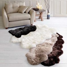 three sheepskin rugs are on the floor in front of a couch and chair