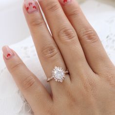 a close up of a person's hand with a diamond ring on their finger