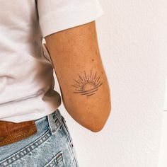 a person with a sun tattoo on their arm