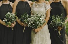 a group of women standing next to each other holding flowers and greenery in their hands