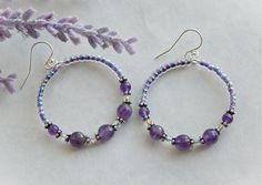 "These amethyst hoop earrings are beaded with light purple glass Czech seed beads, faceted round amethyst beads, and Swarovski crystals. The hoops measure 35mm or 1 1/2\" round. They are hanging from sterling silver french ear wires that have a small silver ball on the front. Earrings do come with the plastic stoppers for the ear wires. If you need stainless ear wires let me know and I can switch them out for you. The amethyst beads are 4mm, 8mm and faceted. They are beautiful high quality stone Plastic Stoppers, Handmade Hoop Earrings, Purple Beaded, February Birthday, Jewelry Words, Earrings Diy, Homemade Jewelry, Amethyst Jewelry, Beading Projects