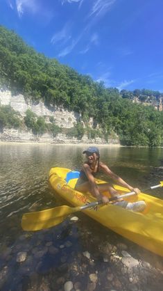 a man riding on top of a yellow kayak