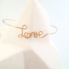 This bangle bracelet is made, to order, by me in my workshop in Beaujolais ⛰️ . I make each jewel with meticulousness and quality materials.  Your bracelet is delivered, packed in a square of washed linen and in its FSC® certified kraft case made in Europe 🇪🇺.  🌈 Personalization 🌈  ■ the personalized message includes up to 9 letters (possibility to include an & or a ♥)  ■ Only the first letter can be lowercase or uppercase, you can specify your choice per message. → By default, first names are capitalized, common words are lowercase (except Love)  ■ All other letters are lowercase.  → For a word in all capitals, contact me for a quote  ■ I can make a heart instead of an o. Ideally replace it with a heart emoji or copy/paste this one: ♥ ■ I can add a heart before or/and after your messa Gold Minimalist Handmade Name Bracelet, Minimalist Handmade Gold Name Bracelet, Gold Handmade Minimalist Name Bracelet, Handmade Minimalist Gold Name Bracelet, Handmade Gold Name Bracelet For Wedding, Dainty Name Bangle Bracelet For Wedding, Gold Handmade Name Bracelet For Anniversary, Elegant Handmade Name Bracelet For Wedding, Custom Name Gold Bracelet For Wedding