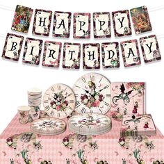 a pink table topped with plates and cups next to a banner that says happy birthday